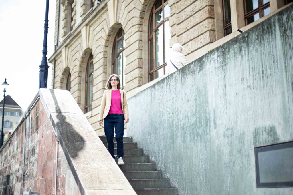 frau-harriet-beveridge-basel-treppe-herunterlaufen-rosa-shirt