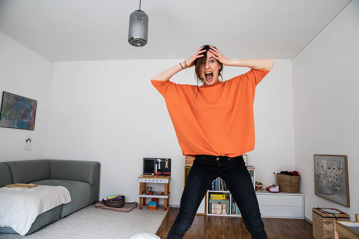 frau-wohnzimmer-schreien-kreischen-oranger-pullover