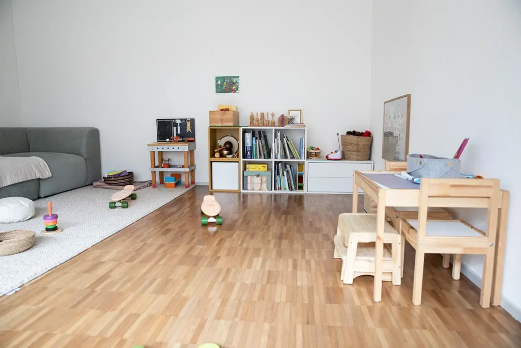 spielecke-wohnzimmer-kindertisch-ikea-bücherregal-sofa-grau-kinderecke