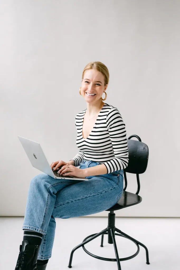 frau-stuhl-laptop-gestreift-tshirt-sweatshirt-schwarz-grau-hintergrund