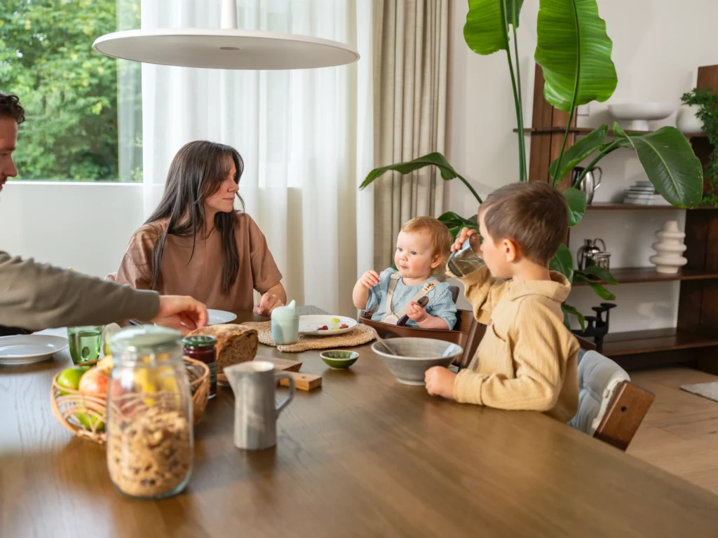 familie-esstisch-frau-dunkle-haare-bub-baby-tripptrapp-pflanze