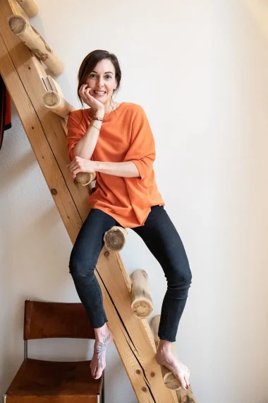 frau-orange-pullover-treppe
