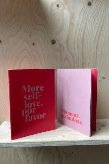 notizheft-journal-roter-hintergrund-holzwand-more-selflove-por-favor-Momentgedanken-holzwand